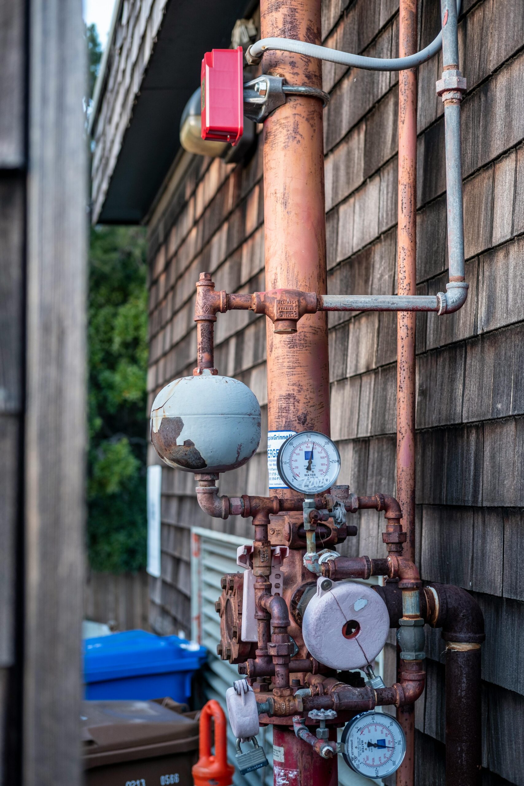 Close-up of a rusty industrial pipe system with gauges, captured outdoors showing intricate details.