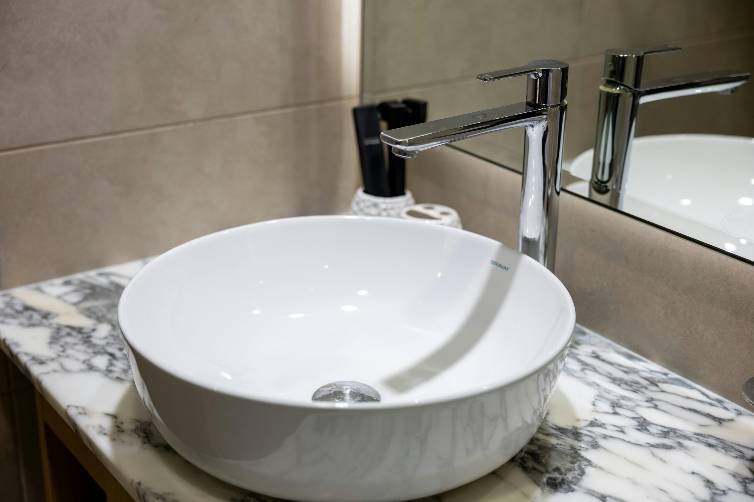 Stylish bathroom sink with a chrome faucet and marble countertop, ideal for contemporary interior design.